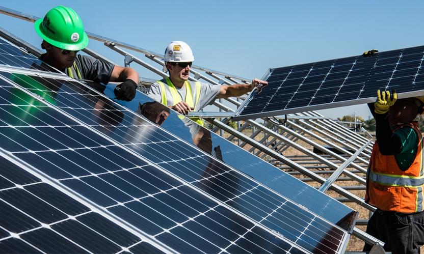 Builders putting together solar panels